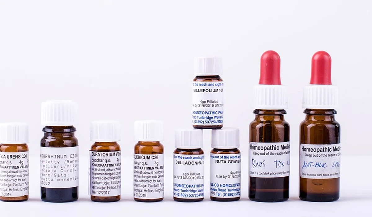 Several small brown medication bottles with labels and two red-topped dropper bottles on a white background