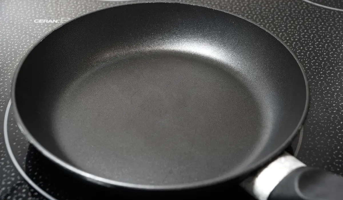 Black non-stick frying pan on a smooth cooktop.