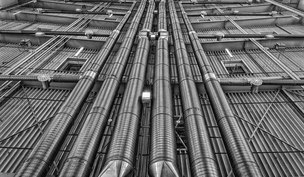 Close-up of metallic HVAC ductwork and wiring in an industrial setting