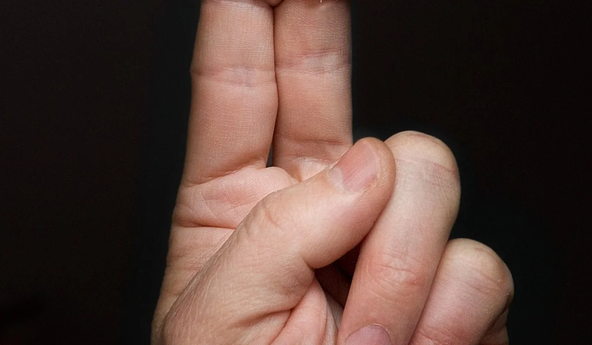 Close-up of a human hand showing a pinching gesture with two fingers, highlighting careful handling and hygiene in bite prevention.