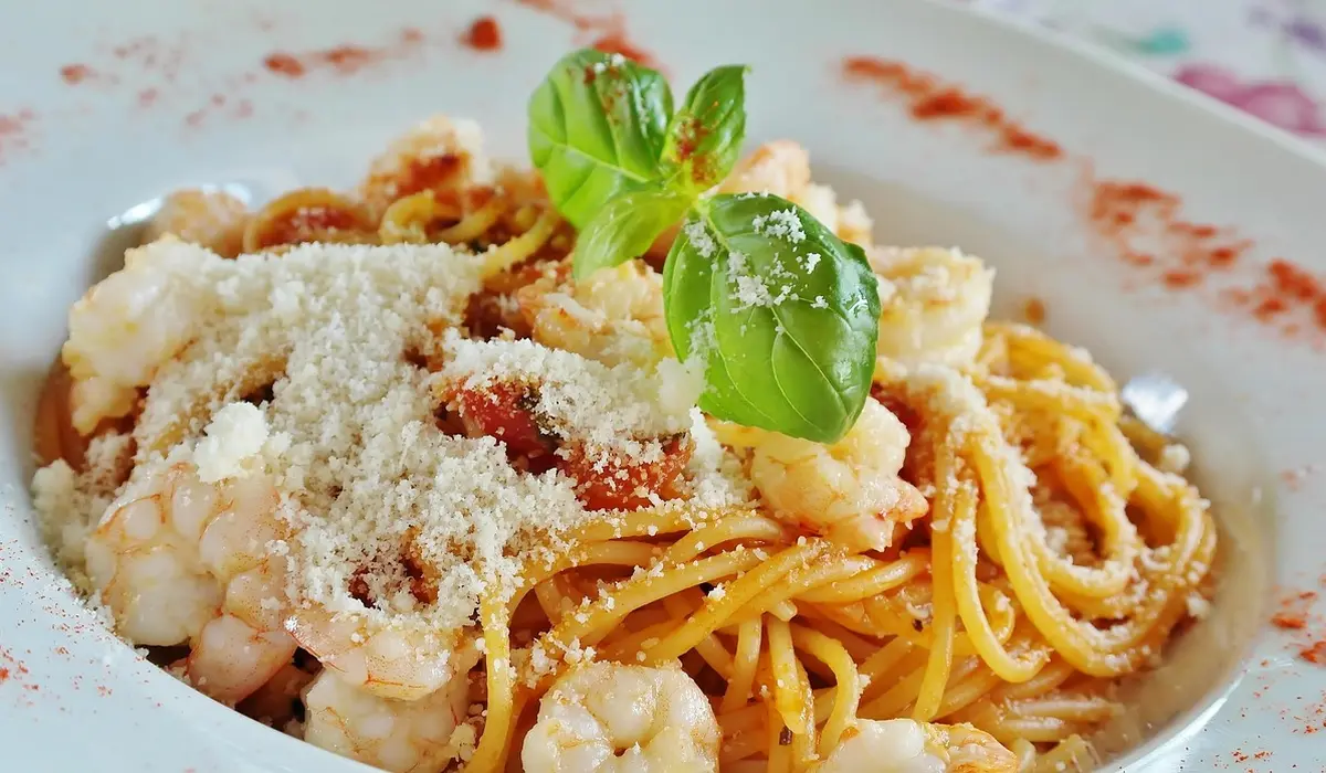 Plate of pasta with grated cheese and a fresh basil garnish