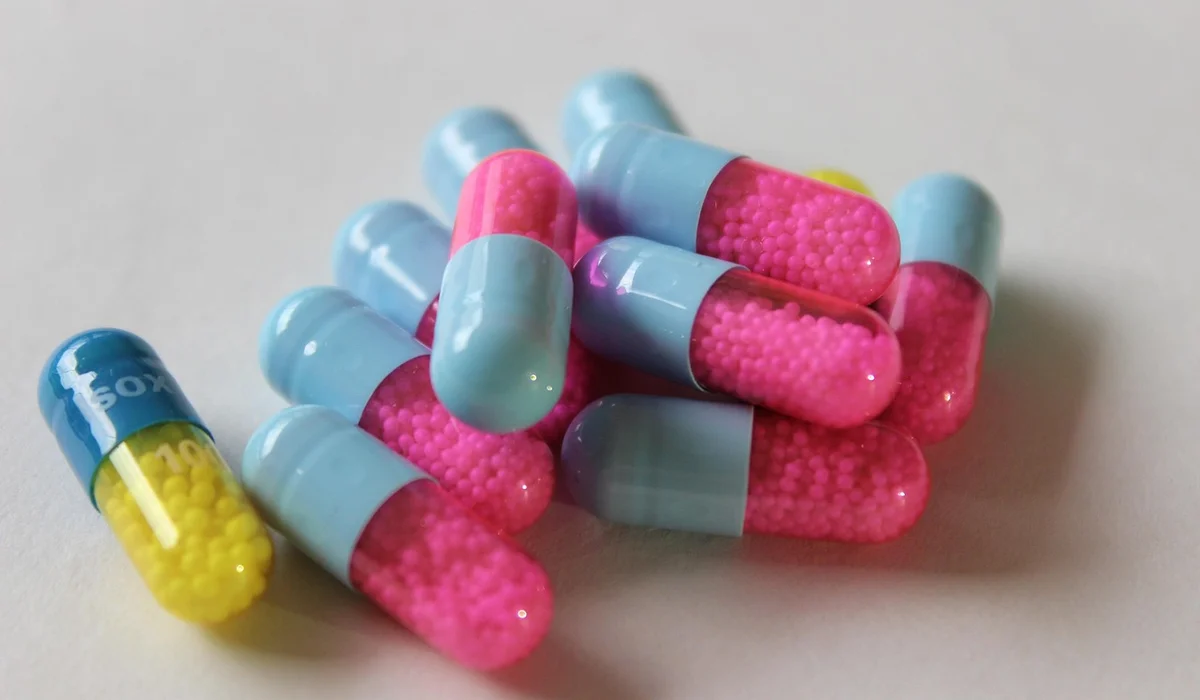 Colorful capsules on a light surface, representing medication administration tools.